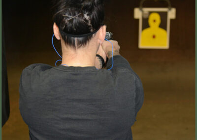 Shooter aiming at an indoor pistol range target